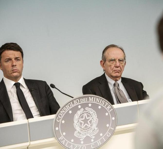 Il presidente del Consiglio Matteo Renzi (s) e il ministro dell'Economia Pier Carlo Padoan (d) durante conferenza stampa al termine della riunione Co
