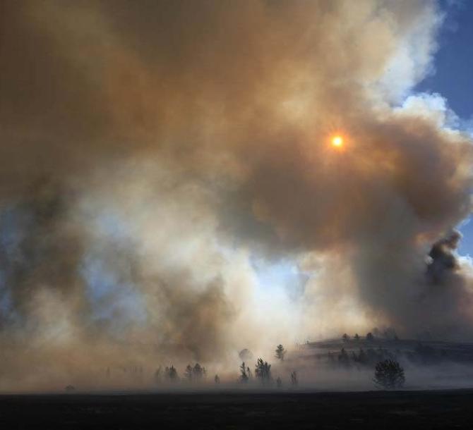 The sun illuminates heavy smoke billowing out of Roger's Canyon Sunday Sept. 19, 2010 10 miles northeast of Laramie, Wyo. (AP Photo/Laramie Boomerang