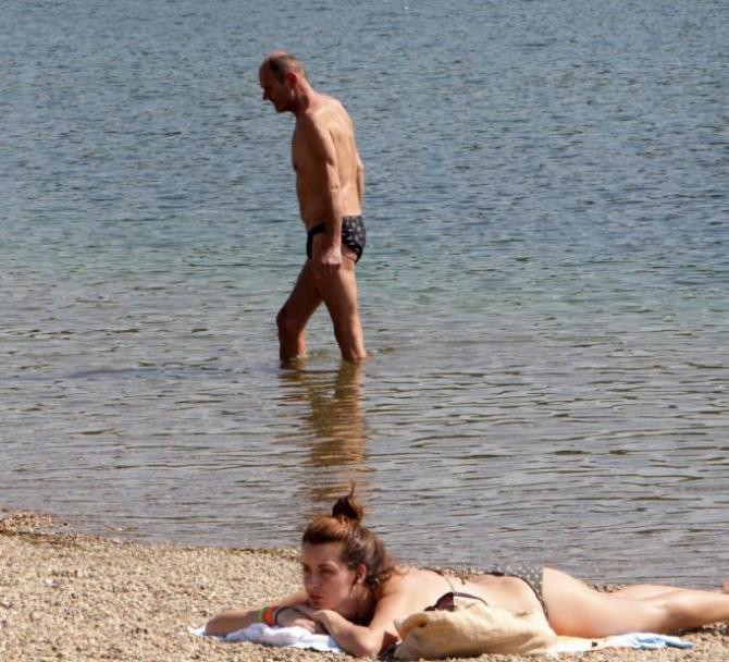 epa05247829 People sit at a beach on a warm day at the Ada Ciganlija Lake in Belgrade, Serbia 07 April 2016. Meteorologists announced highs of 28 deg